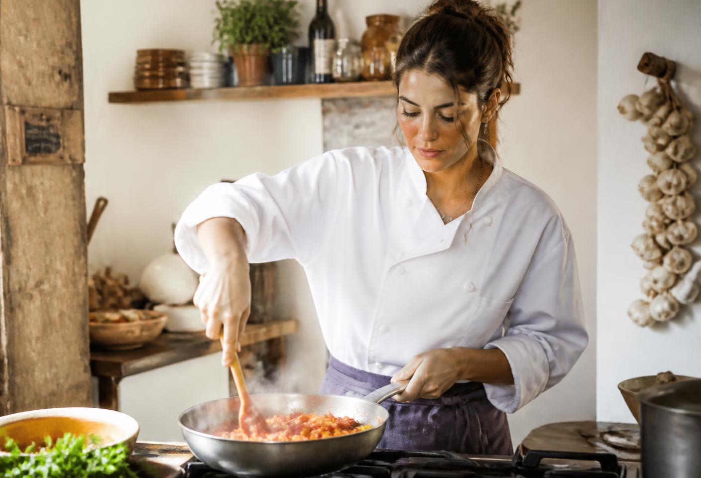 Sofia preparando massa com molho artesanal na frigideira